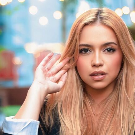 Young woman with blonde hair posing stylishly outdoors, capturing a modern fashion essence.